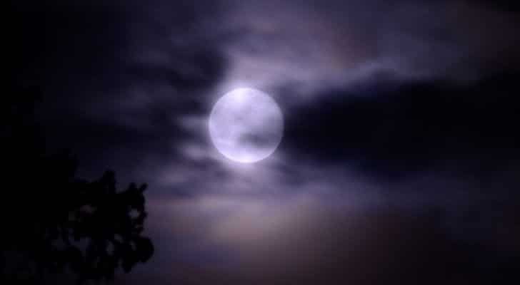 A picture of the moon from Earth with a chilly cloudy sky