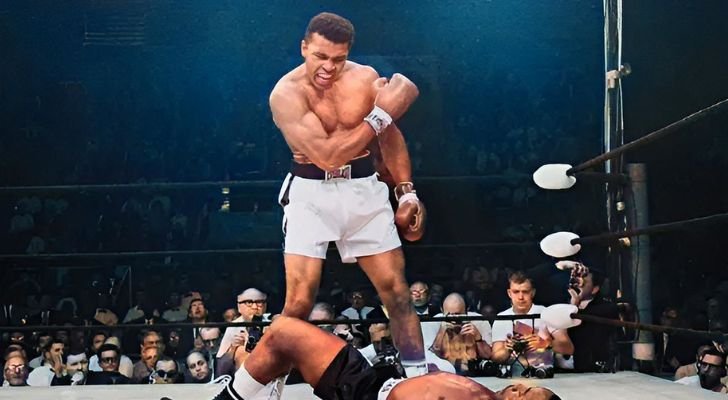 Muhammad Ali standing over his opponent in a boxing ring