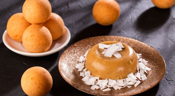 A custard-like desert on a plate, topped with coconut shavvings