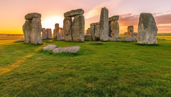 Stonehenge at sunset, a prehistoric monument in England with large standing stones on a grassy field