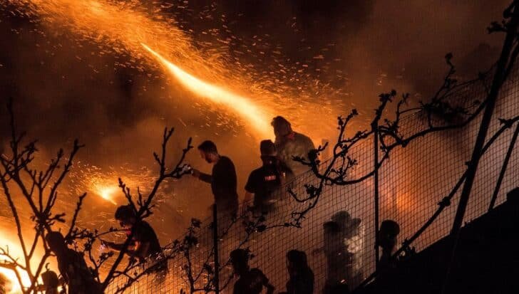 People participating in a nighttime Easter firework event with bright sparks and flames illuminating the scene against a dark backdrop