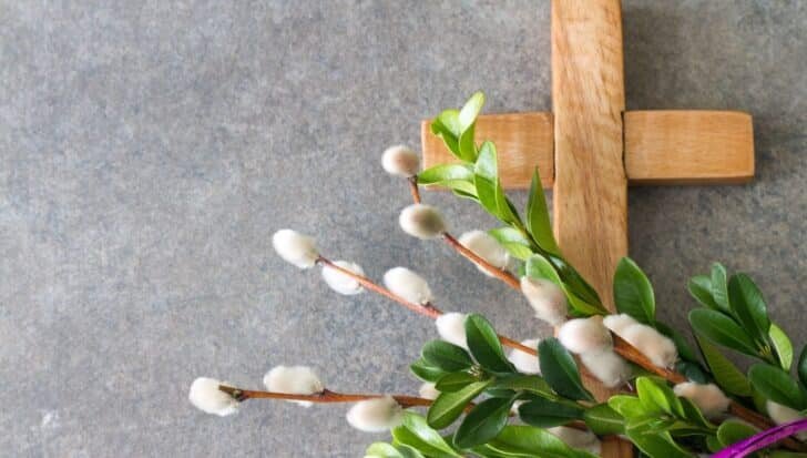Wooden cross with green leaves and pussy willow branches, emphasizing the use of green for Palm Sunday