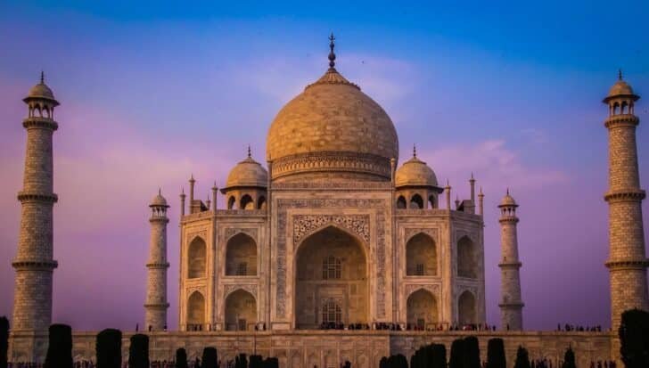 The Taj Mahal in the evening light, showcasing its large dome and four minarets, highlighting its role in iconic architecture