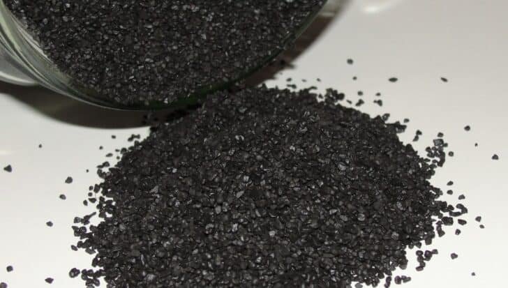 Black powder granules spilled from a container, related to fireworks composition