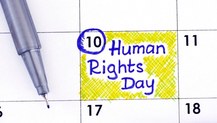 Calendar page with December 10 highlighted for Human Rights Day, blue pen nearby