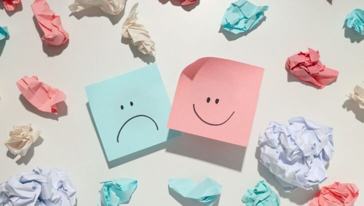 Two sticky notes with facial expressions, one happy and one sad