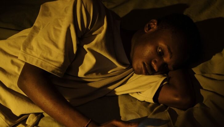Person lying in bed with a distressed expression